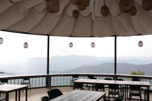 a restaurant with tables and chairs and mountains in the background at Wawee Sunset, Doi Chang Chiang Rai in Ban Huai Khai
