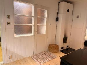 a kitchen with a refrigerator and a door with windows at Tunnelmallinen saunallinen ullakkohuoneisto Ravintola Sampon yläkerrassa in Kuopio