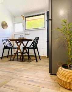 a dining room with a table and a refrigerator at Emeraude tropicale in Goyave +11 photos