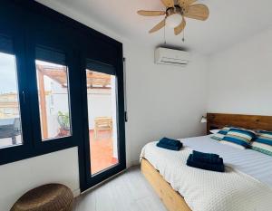 a bedroom with a bed with a fan and a window at Casa Dolce Vita in Palamós