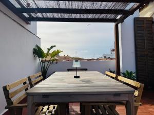 a wooden table and chairs on a patio with a window at Casa Dolce Vita in Palamós