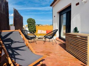 a deck with chairs and a hammock on a patio at Casa Dolce Vita in Palamós