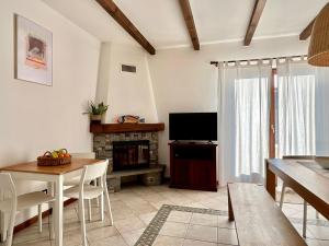 a living room with a television and a table and chairs at Casa Bùri in Trarego