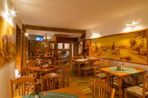 un restaurant avec des tables et des chaises et une peinture murale. dans l'établissement Pension Zum Schotten, à Zella-Mehlis