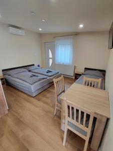 a bedroom with a bed and a table and chairs at Borti Apartman in Zamárdi +30 photos