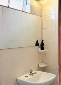 a bathroom with a sink and a mirror at Lo de Sarita Hostería in Necochea