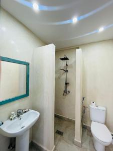 a bathroom with a white toilet and a sink at Appartement Michel Uniquement les familles in Oualidia