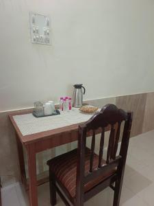 a table with a chair and a table with a coffee pot on it at Hotel Sukhdev in Nawalgarh