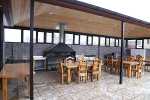 a patio with tables and chairs and a fireplace at Qusar Shahdag Garden Hotel in Qusar