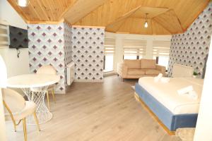 a bedroom with a bed and a table and a couch at Qusar Shahdag Garden Hotel in Qusar
