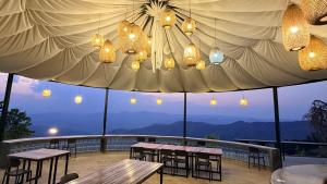 a patio with tables and chairs under a tent at Wawee Sunset, Doi Chang Chiang Rai in Ban Huai Khai +29 photos