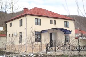 a large white house with a red roof at Qusar Shahdag Garden Hotel in Qusar