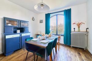 a dining room with a table and blue cabinets at Ker Berthe - Maison spacieuse - lumineuse - 4 chambres in Cesson-Sévigné +11 photos