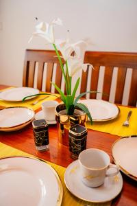 a wooden table with plates and cups and a plant at Zeylon Villa Talalla in Matara +21 photos