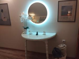 a bathroom sink with a mirror and a vase of flowers at Lacus Orestias - unlimited view in Kastoria +29 photos