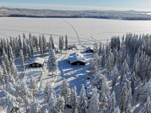 an aerial view of snow covered trees and huts at Villa Moinalahti in Sirkkakoski