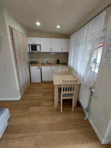a small kitchen with a table and a chair at Borti Apartman in Zamárdi