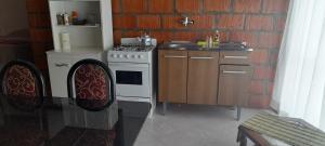 a kitchen with a stove and a counter with chairs at Kallpa in Tinogasta
