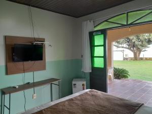 a room with a bed and a sliding glass door at Pousada Marajo in Salvaterra