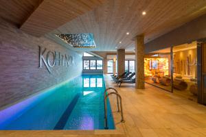 a swimming pool in a building with a sign on the wall at Hôtel Koh-I Nor by Les Etincelles in Val Thorens