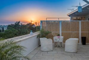 a balcony with two chairs and a table with the sunset at B&B Il Palazzotto di Luca Luxury Suites in Lecce