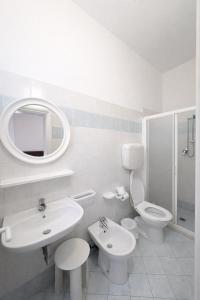 a bathroom with a sink and a toilet and a mirror at Hotel Giove dipendenza Hotel Fiamma in Cesenatico +47 photos