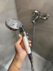 a person holding a shower head in a bathroom at Noblesse residence - parking Militari residence Chiajna Dudu in Chiajna
