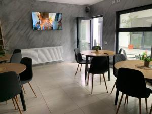 a restaurant with tables and chairs and a tv on the wall at PARAVANHouse in Constanţa +9 photos