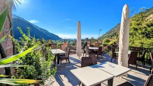 a patio with tables and chairs with mountains in the background at Résidence Le Porto in Porto Ota