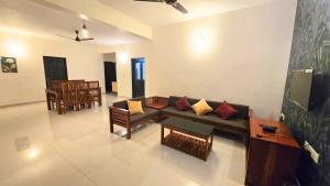 a living room with a couch and a table at Centur Apartments in Changanācheri