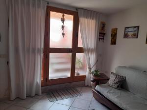 a living room with a window and a couch at Casafreccia in Carloforte
