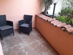 a patio with two chairs and a wall at Casafreccia in Carloforte