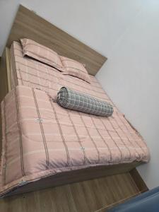 a bed with a pink comforter and pillows on it at Đức Khoa Villa Phu Quoc in Phú Quốc