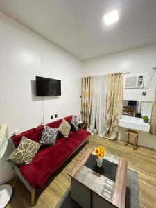 a living room with a red couch and a table at Antara Residential Condominium in Talisay