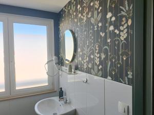 a bathroom with a sink and a mirror at Hotel Restaurant L'Atlantique in Saint-Jean-de-Monts