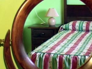 Apartamentos Picu Castiellu في La Galguera: مرآة في غرفة النوم مع سرير ومصباح