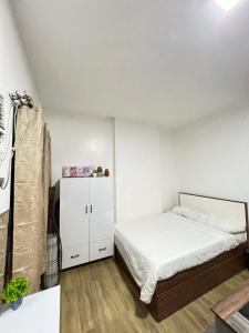 a bedroom with a white bed and a white cabinet at Antara Residential Condominium in Talisay +17 photos