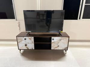 a tv on a dresser with a person standing on it at The Beach House in Cochin