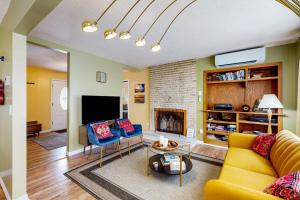 a living room with a yellow couch and a fireplace at Chautauqua Lake Views! Bemus Point Getaway in Bemus Point