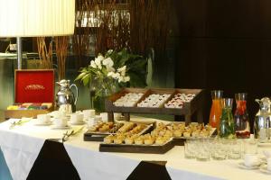 a table with a buffet of pastries on it at Starhotels Excelsior in Bologna +45 photos