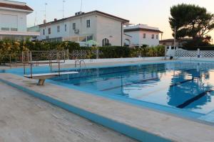 a swimming pool with a bench in front of a building at Luca's House - Villa sul mare con piscina in Giovinazzo