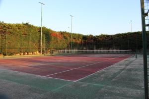 a tennis court with trees in the background at Luca's House - Villa sul mare con piscina in Giovinazzo