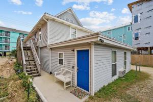 a tiny house with a blue door and a stairs at Sand Dollar Suites 1 in Carolina Beach