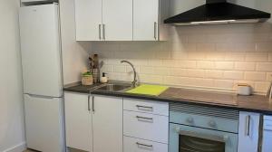 a kitchen with white cabinets and a sink at Casa Bueu Pontevedra in Bueu