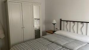 a bedroom with a bed and a dresser with a lamp at Casa Bueu Pontevedra in Bueu