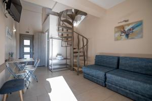 a living room with a blue couch and a spiral staircase at Elia Luxury Apartments in Stavros