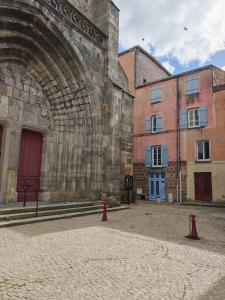 an old building with a red fire hydrant in front of it at L'immeuble du Monde Rose - Appartements neufs climatisés - classés 3 étoiles - Vic le Comte - Auvergne in Vic-le-Comte