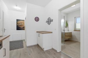 a white kitchen with a counter and a sink at Ferienwohnungen "Godewind", Appartements mit Balkon oder Terrasse in Zinnowitz +71 photos