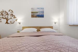 a bedroom with a bed with a pink comforter at Ferienwohnungen "Godewind", Appartements mit Balkon oder Terrasse in Zinnowitz