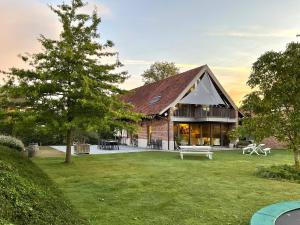 ein Haus mit einem großen Garten und einem Baum in der Unterkunft Hotel - B&B PassaDia in Zwevegem